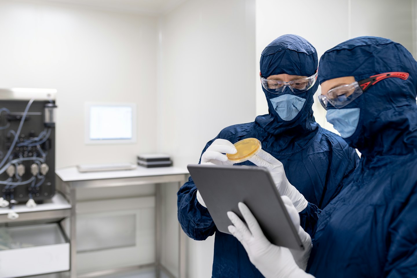 Scienziati che esaminano una capsula di Petri in un laboratorio sterile.